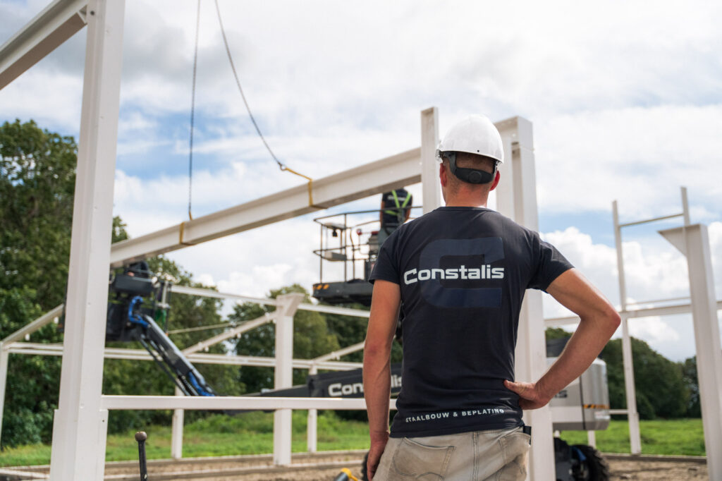 Constalis-monteur bekijkt de staalconstructie op de bouwplaats