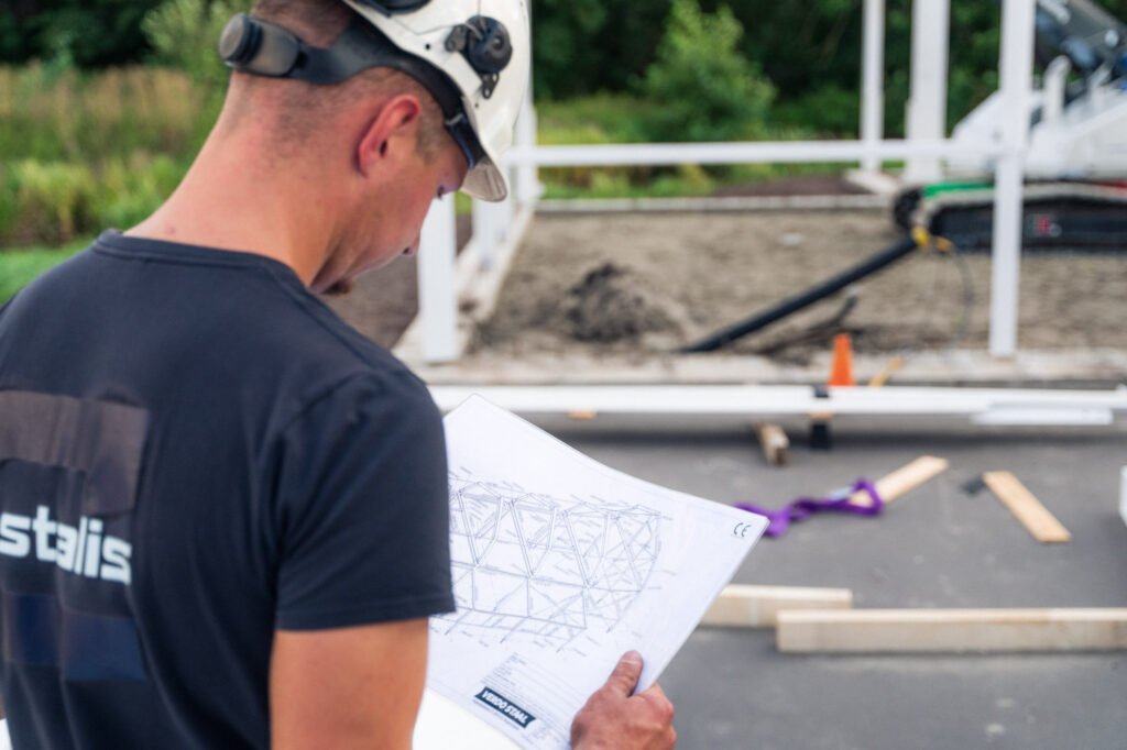 Monteur bekijkt de werktekening op de bouwplaats