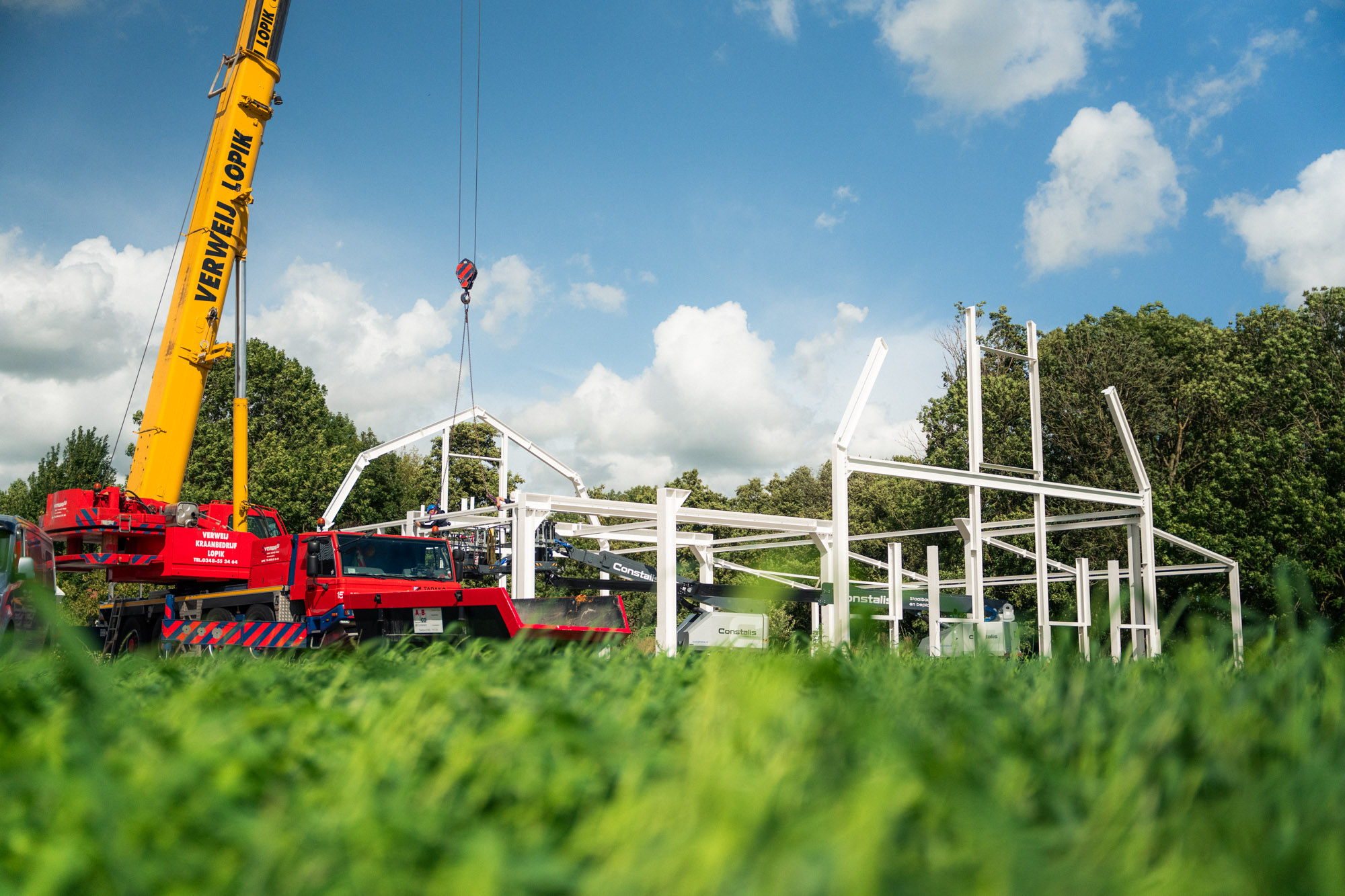 Mobiele kraan en staalconstructie tijdens de montage