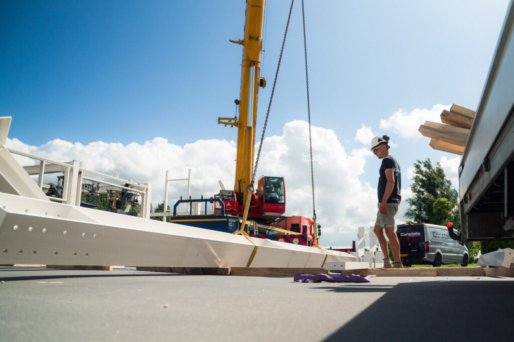 Staal wordt van de vrachtwagen gelost op de bouwplaats